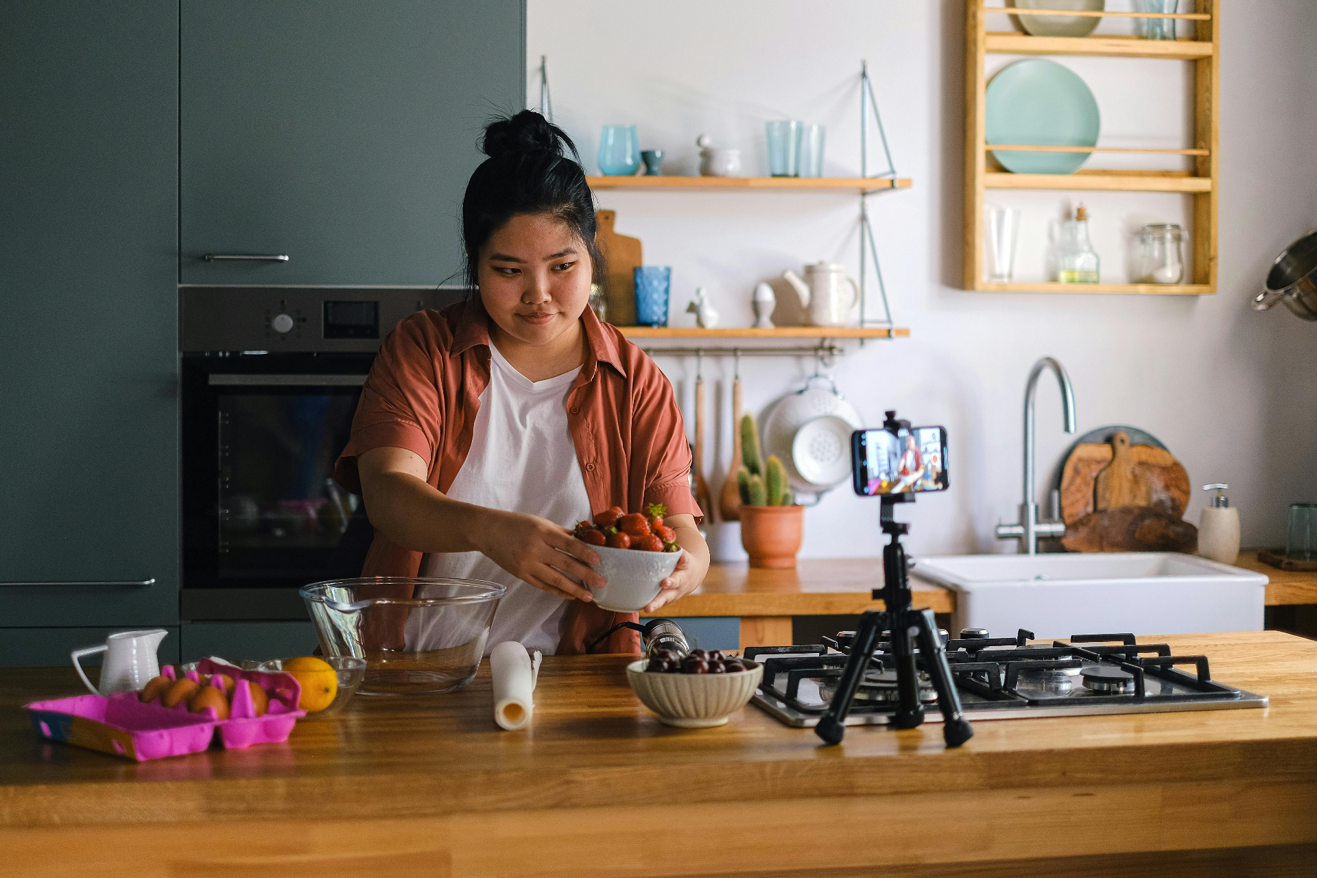 Home cook styling food and filming content in a bright modern kitchen